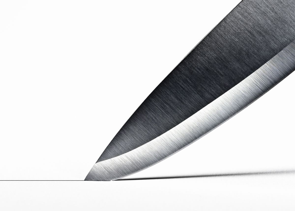 Steel knife blade cutting into surface
