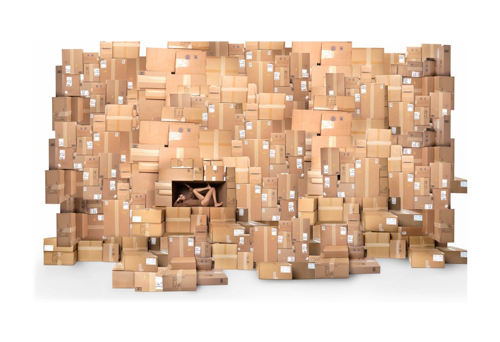 model inside a wall made of boxes