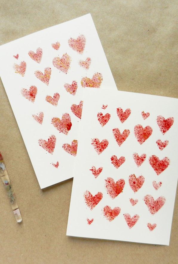 diy valentines day card idea with small red hearts of various sizes stencils on a white card