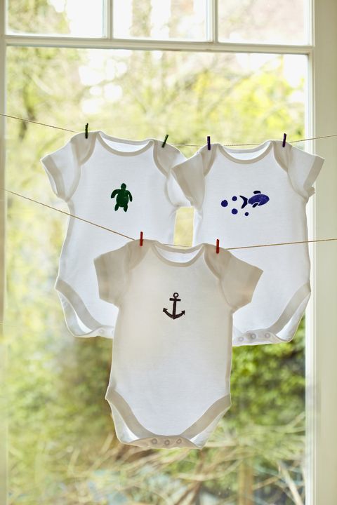 Stencilled onesies on line by window