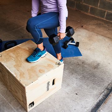woman doing a rep of a step up with dumbbells, running MISBHV injury
