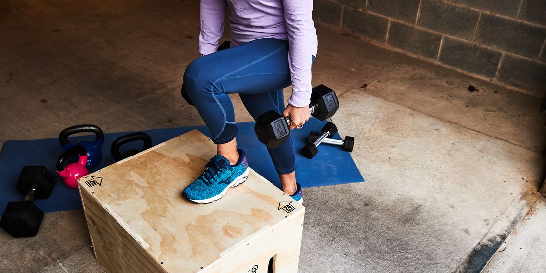woman doing a rep of a step up with dumbbells, running Smith injury