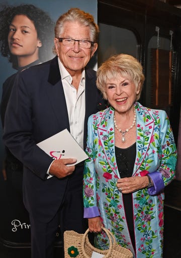 stephen way and gloria hunniford attend the press night performance of cinderella at the gillian lynne theatre, him in a blue suit with white shirt, and her in a light blue floral jacket over a black dress