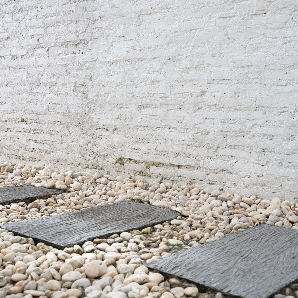 stepping stones and white brick wall