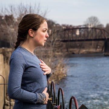 a runner taking a deep breath by a river