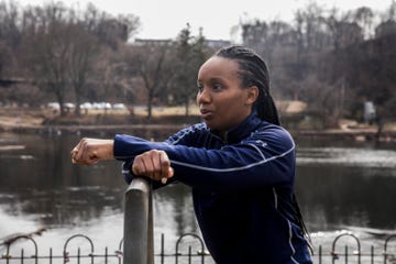 person leaning on a fence by a calm river