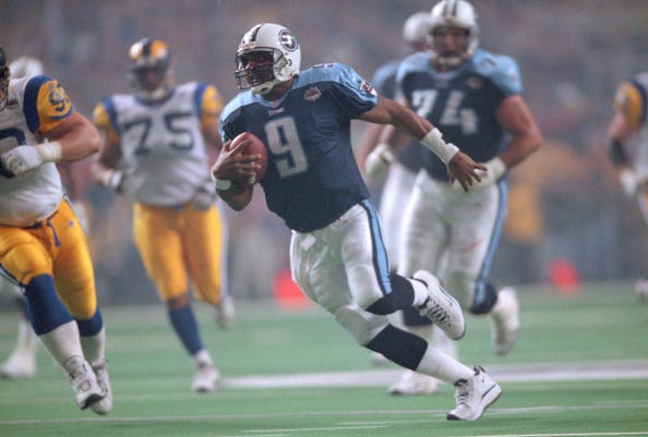 tennessee titans quarterback steve mcnair running with the football as players from the st louis rams chase him during super bowl xxxiv