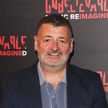 steven moffat stands looking at the camera and smiling