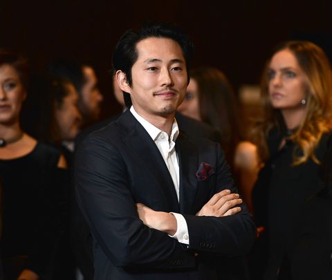 steven yeun standing with his arms folded