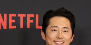 steven yeun smiling for cameras at the premiere of the netflix series beef