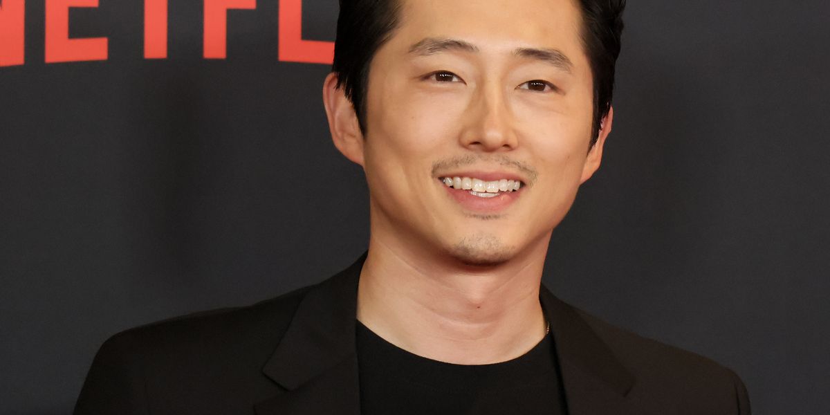 steven yeun smiling for cameras at the premiere of the netflix series beef