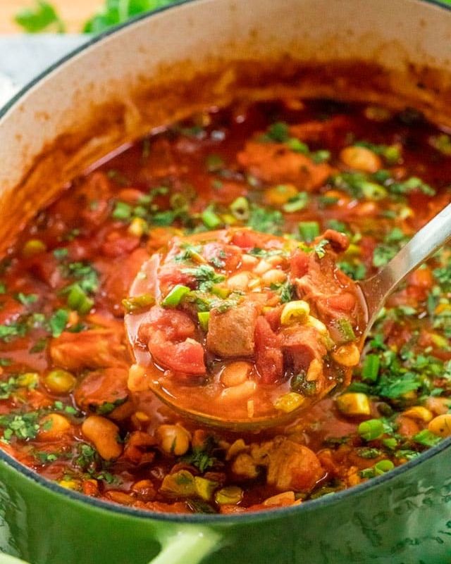 mexican pork stew in green pot with ladle