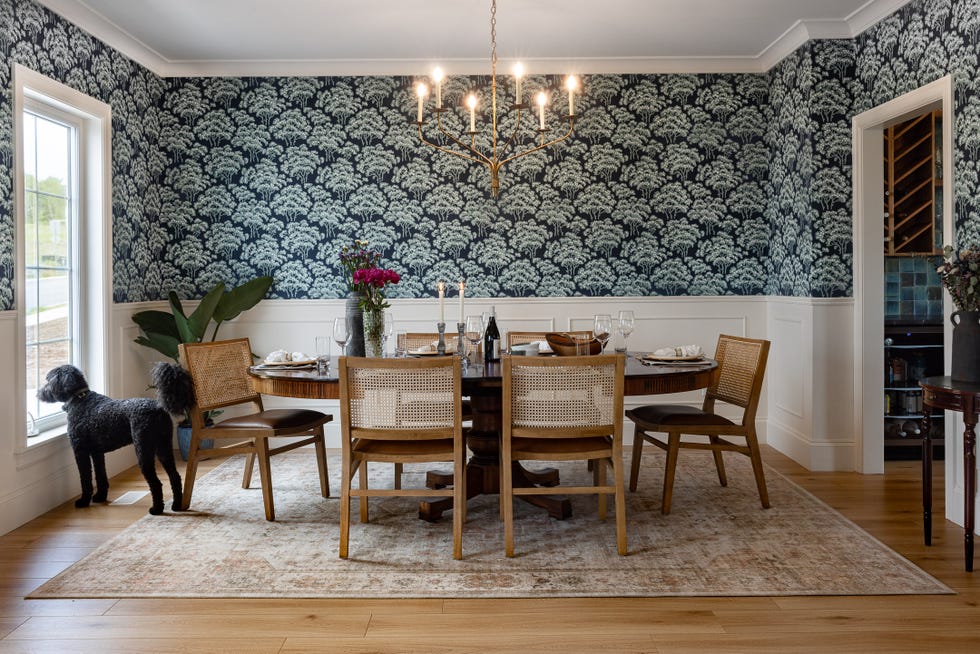 dining area featuring a round table set for a meal surrounded by chairs and a window with a view