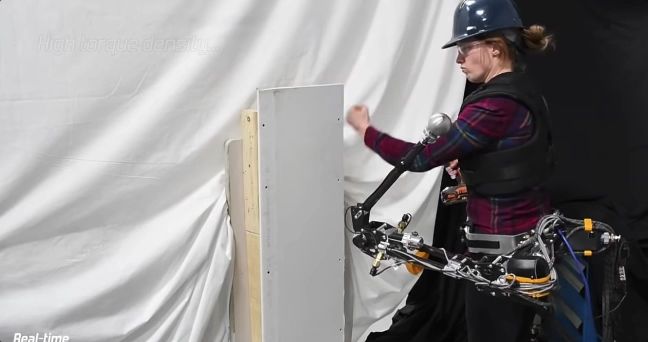 a waist mounted hydraulic robot arm smashes through a piece of drywall