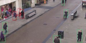 a group of people walking in a public street are highlighted in green bounding boxes if they are maintaining adequate distance from others those who get too close to others are highlighted in red bounding boxes