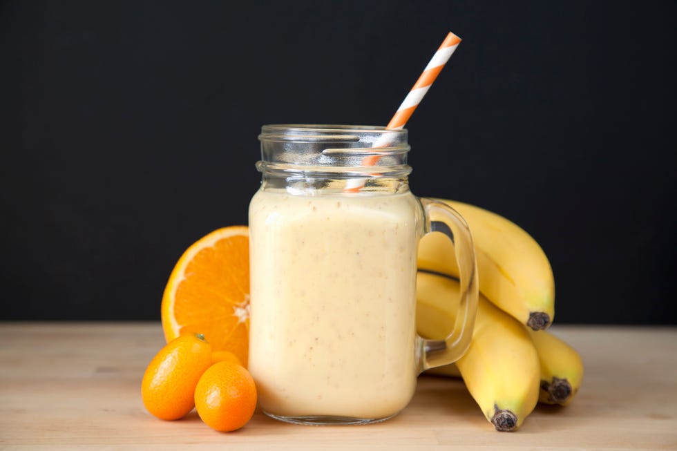 still life of fresh banana, orange and kumquat smoothie