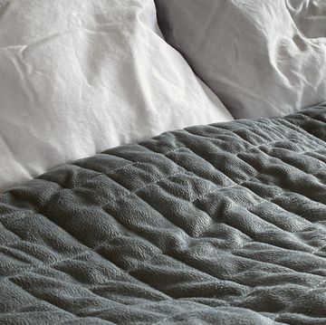 a grey weighted blanket on a bed