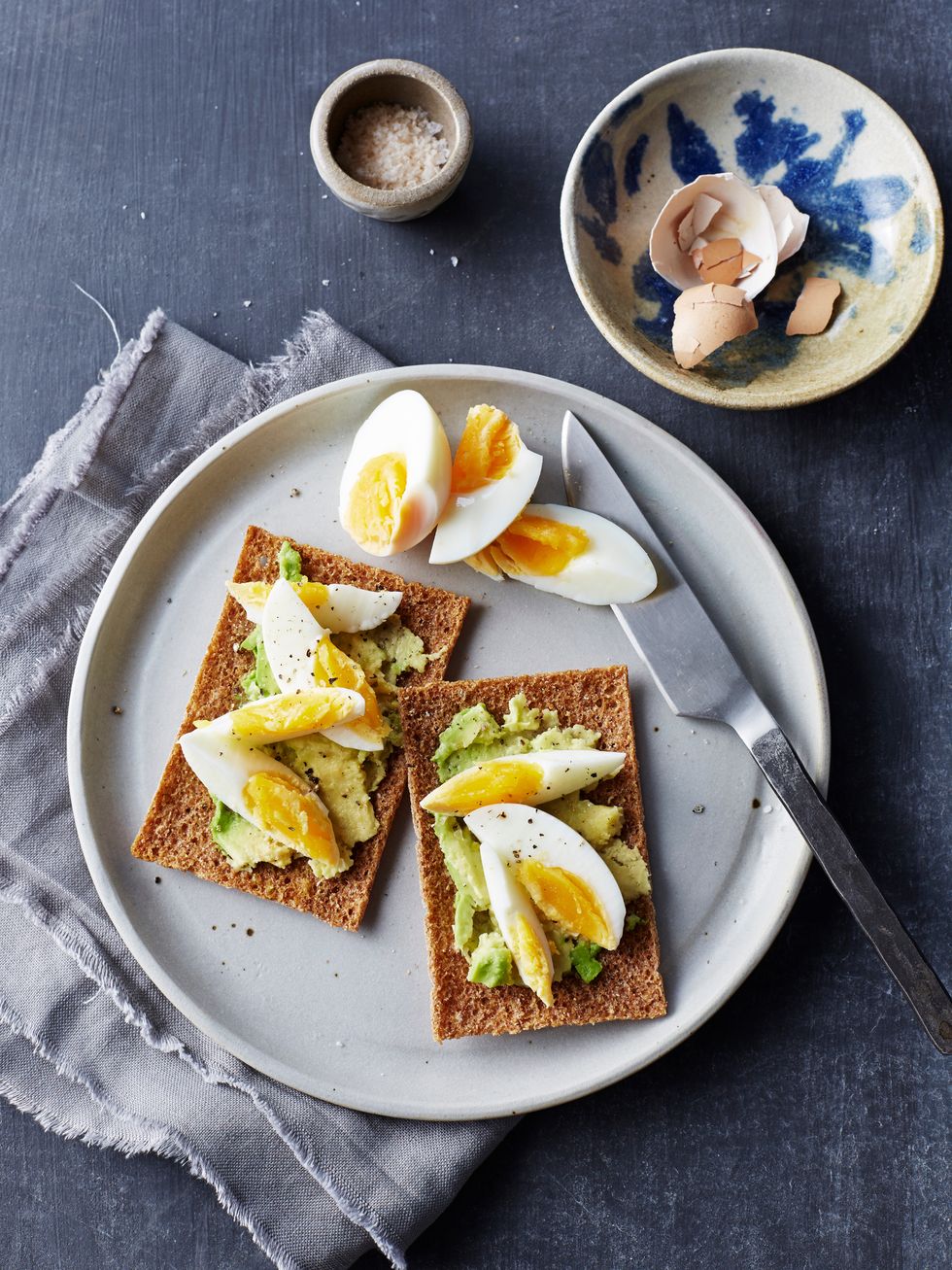 Still life of rye crackers with boiled sliced eggs on plate, overhead view