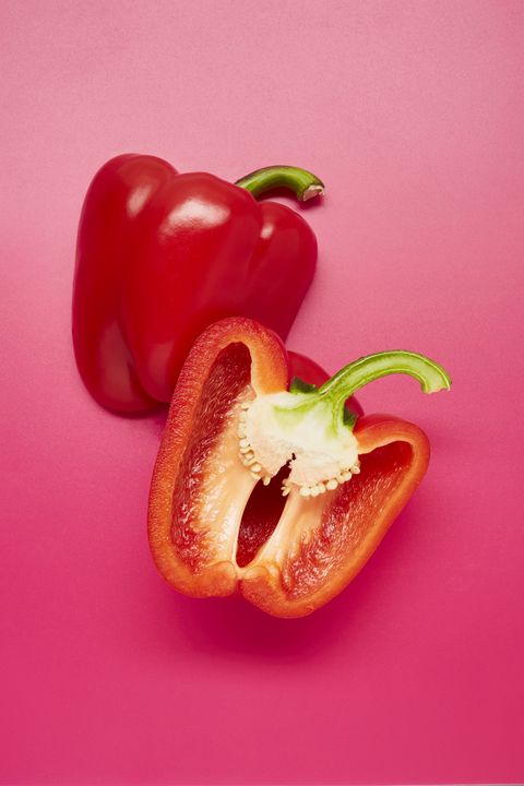 still life of sliced red bell peppers on pink background