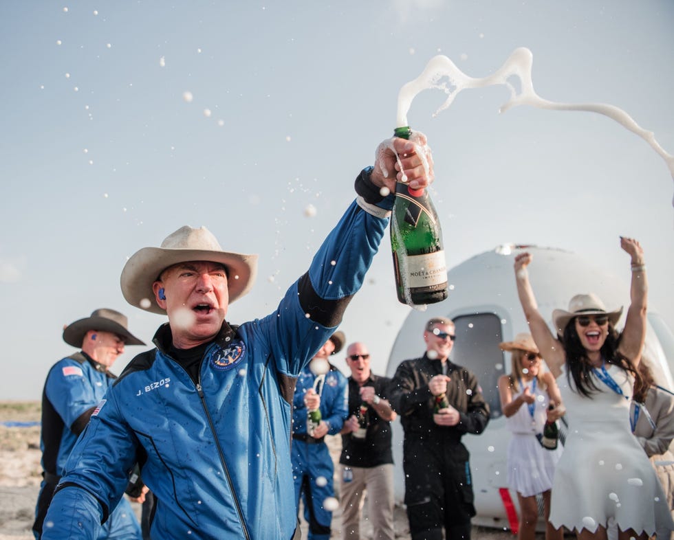 https://i.natgeofe.com/n/ec2be0aa-0666-44dd-8916-c1ab6b58bf12/STOCK_blue-origin-first-human-flight-l0-jeff-bezos-celebration.jpg Negen dagen na Branson trok Amazonoprichter Jeff Bezos de champagne open om zijn eigen uitstapje naar de rand van de ruimte te vieren Hij en drie medepassagiers vlogen bijna honderd kilometer boven het aardoppervlak aan boord van de New Shepard de suborbitale raket van Bezos bedrijf Blue Origin