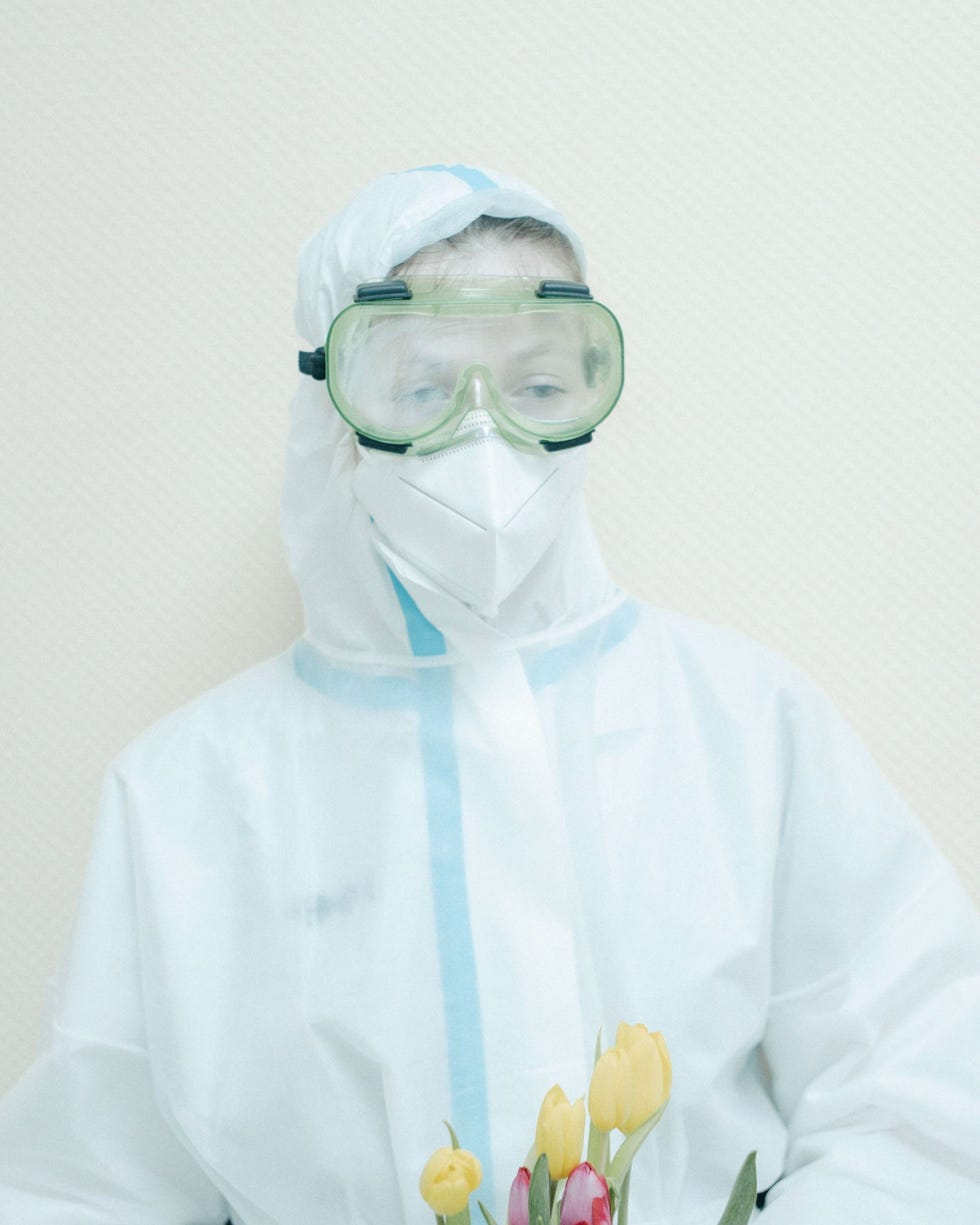 Moscow, Russia MOSKOU RUSLANDOp 9 mei 2020 de Dag van de Overwinning in Rusland houdt een verpleegster in volledig beschermende kleding een bos bloemen vast voor een patint in Hospitaal Nr 52 in Moskou Op Ruslands belangrijkste nationale feestdag wordt de overgave van naziDuitsland in 1945 herdacht Hoewel de feestelijkheden dit jaar vanwege de pandemie wat minder uitbundig waren organiseerde het ziekenhuis een klein eerbetoonaan opgenomen veteranen en hun familieleden