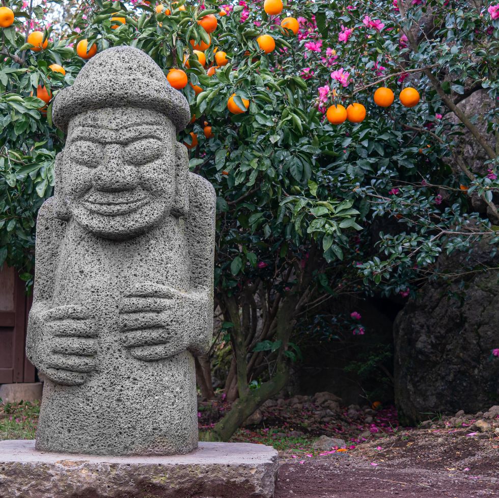stone harubang and tangerine, the symbols of jeju island in korea
