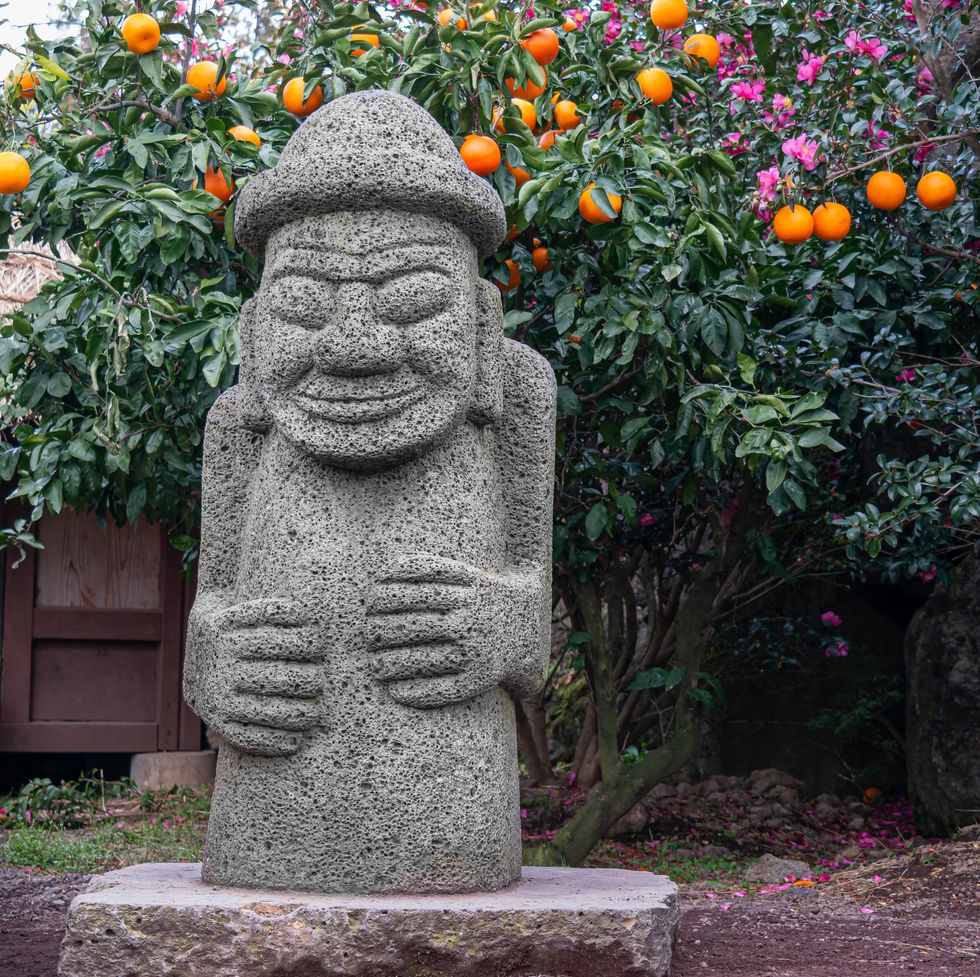 stone harubang and tangerine, the symbols of jeju island in korea