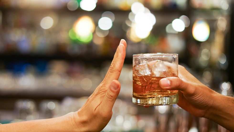mano che dice no a un bicchiere di alcol