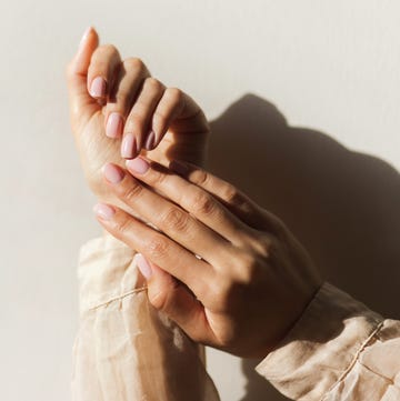 female hands with beautiful manicure light pink nails on beige background. neat female hands after hardware manicure. manicure, nail, skin care, beauty salon concept. stop nail varish chipping
