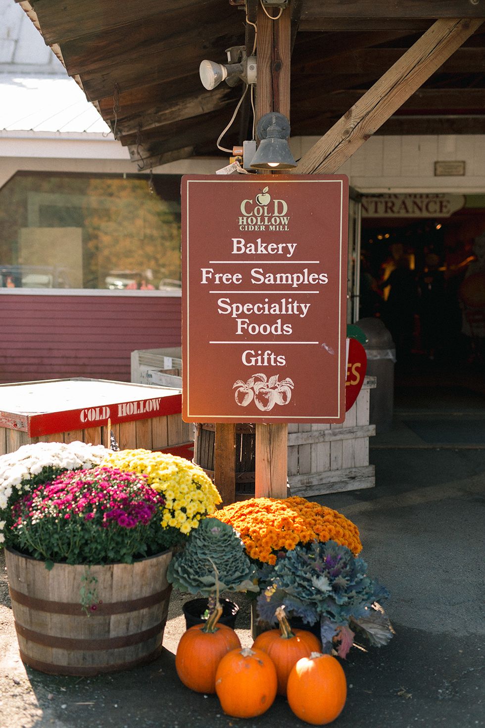 a sign at cold hollow cider mill with flowers and pumpkins