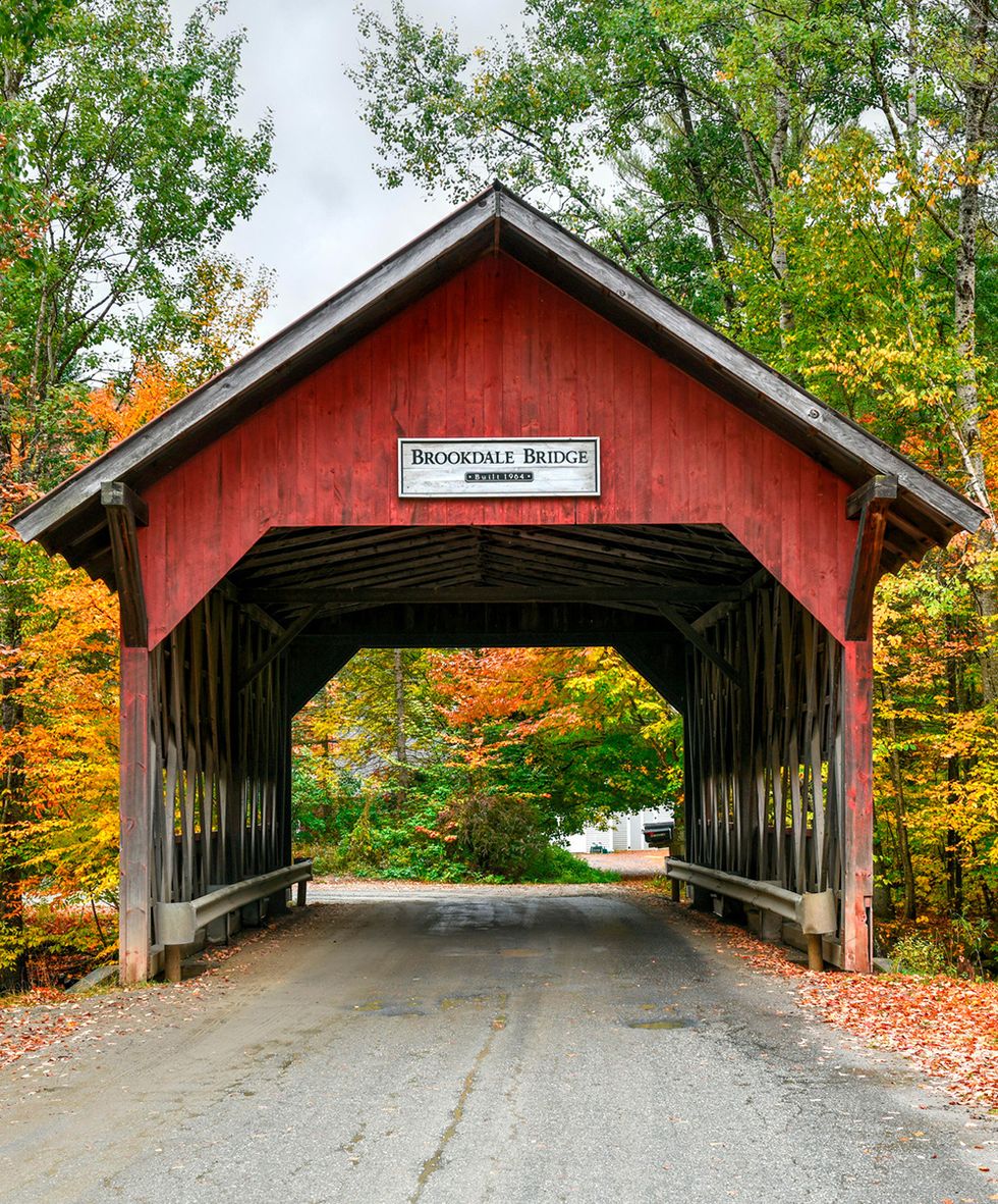 a red covered bridge with a sign in stowe vermont