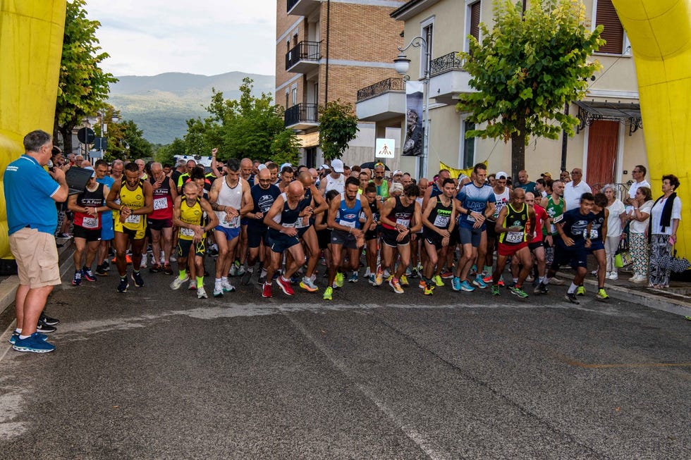 participants lined up at the starting point of a race under a yellow arch