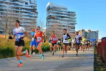 runners participating in a race along a pathway with modern buildings in the background