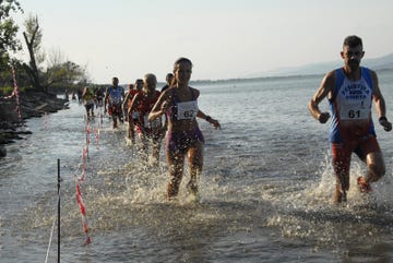participants competing in a water race along a shoreline