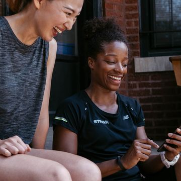 twee vrouwen bekijken hun strava activiteit na een rondje hardlopen