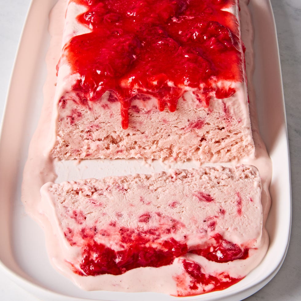 strawberries and cream semifreddo topped with a fresh strawberry sauce on a plate