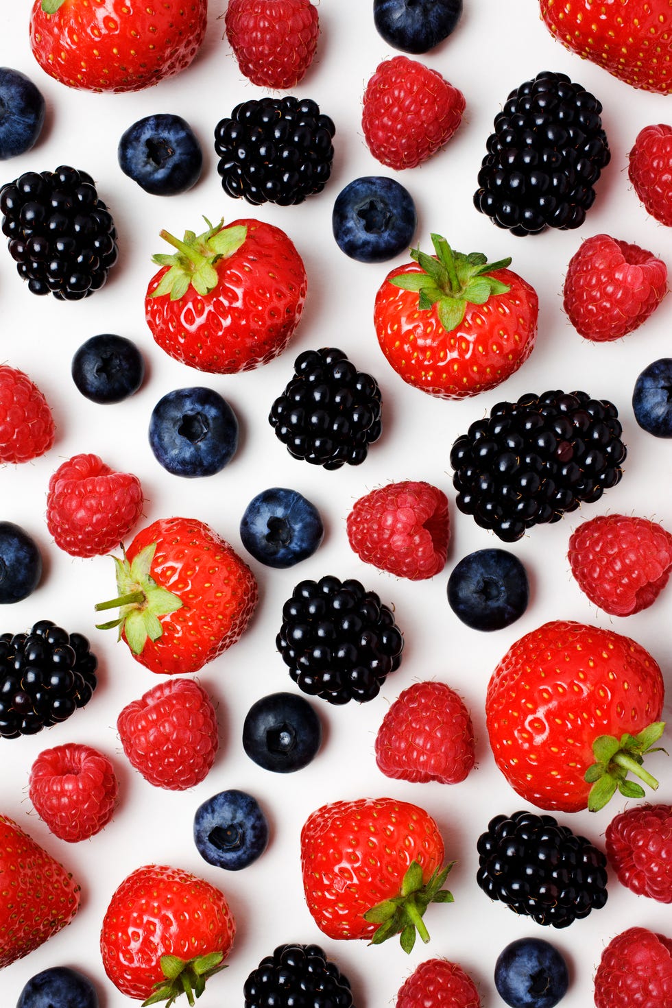 strawberries, raspberries, blackberries and blueberries on a white background