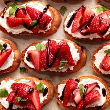 sliced strawberries on top of ricotta spread on crostini drizzled with balsamic