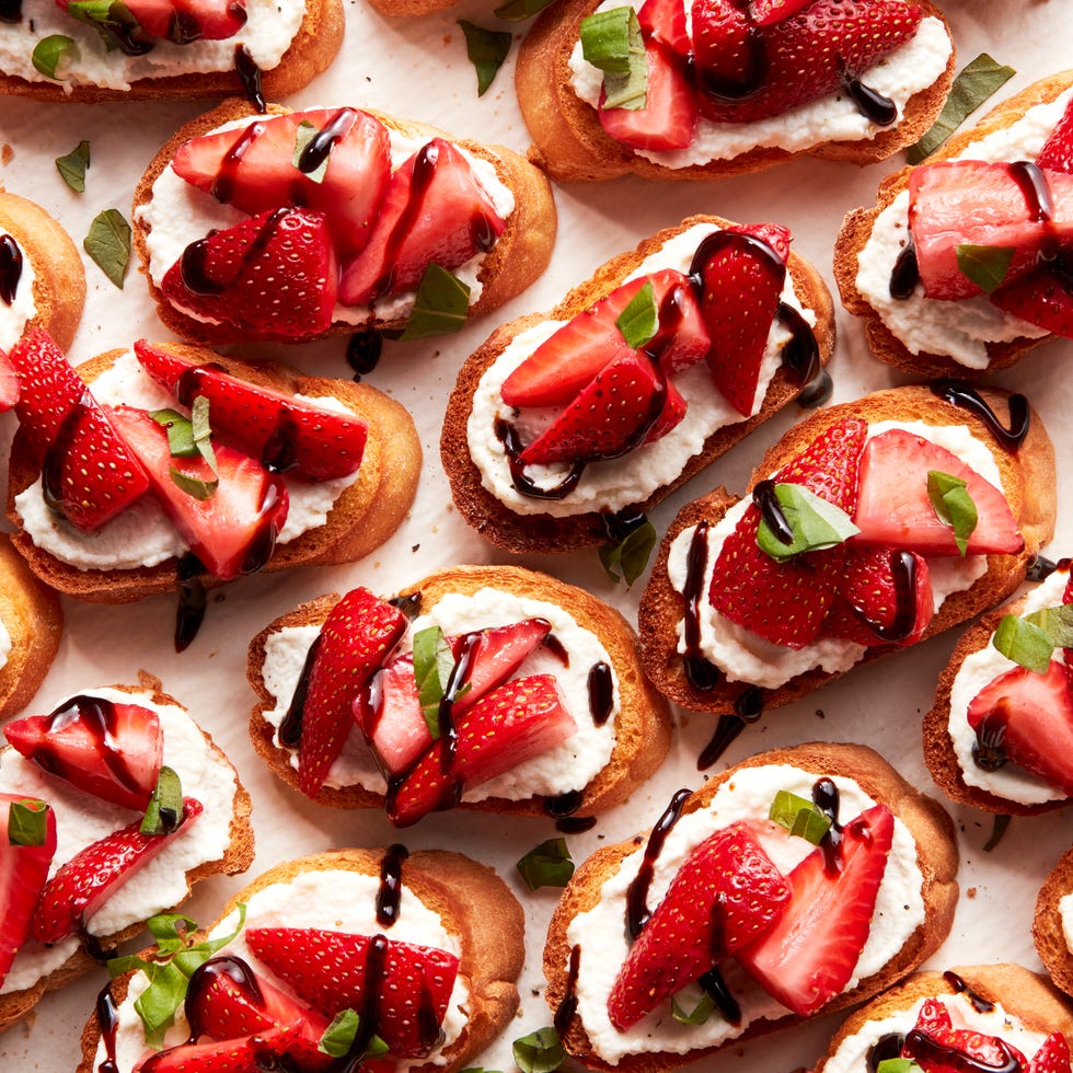 sliced strawberries on top of ricotta spread on crostini drizzled with balsamic