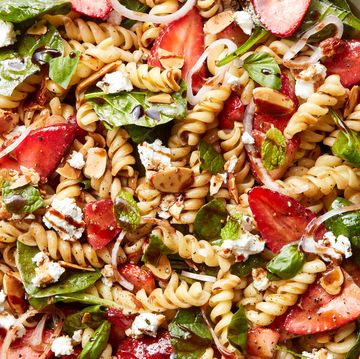 pasta salad tossed with spinach, sliced strawberries, cheese, and balsamic dressing
