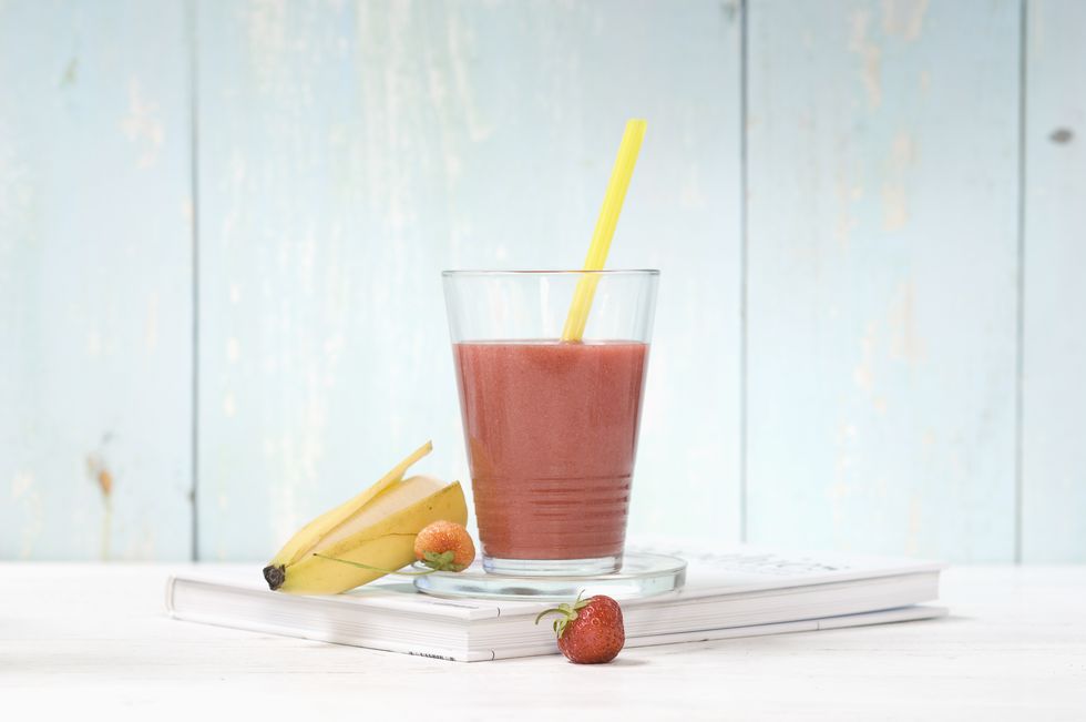 strawberry banana smoothie in glass with drinking straw
