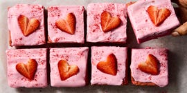 pink brownies topped with pink icing and strawberry hearts