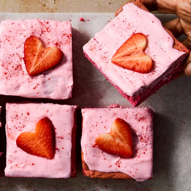 pink brownies topped with pink icing and strawberry hearts