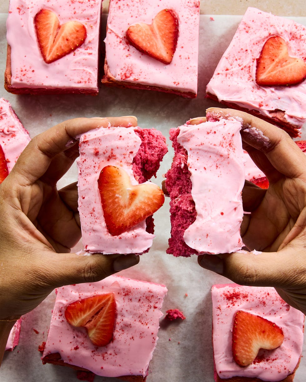 pink brownies topped with pink icing and strawberry hearts
