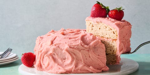 strawberry cake with icing and topped with whole strawberries
