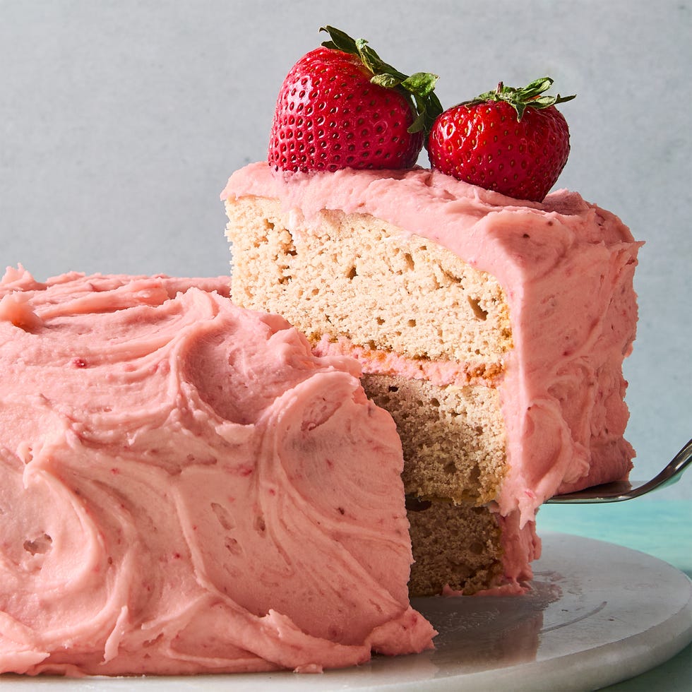 strawberry cake with icing and topped with whole strawberries