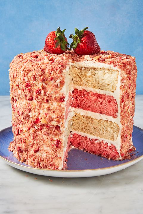 strawberry crunch cake with alternating white and pink layers on a blue plate