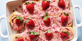 cinnamon rolls topped with strawberry frosting, crunch pieces, and strawberries