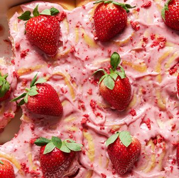 cinnamon rolls topped with strawberry frosting, crunch pieces, and strawberries