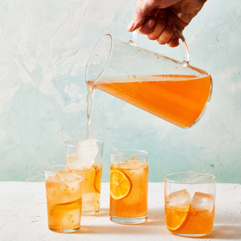 strawberry meyer lemon orange spritz being poured into glass drinking glasses